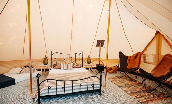 Inside a furnished pre-pitched canvas tent, double bed, two chairs - bohemian style